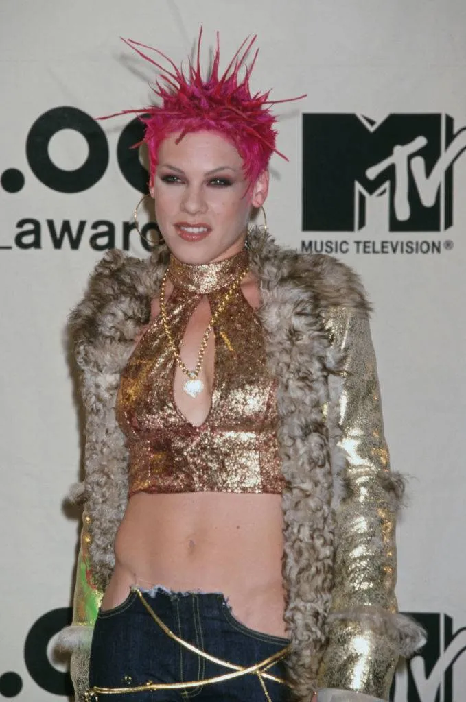 pink with spiky pink hair and gold top and fur jacket