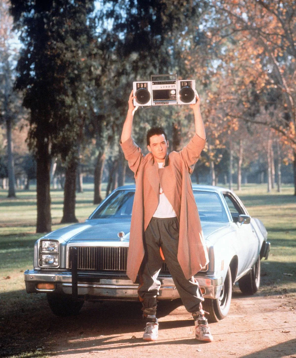 man holding a boombox in front of a car in say anything...