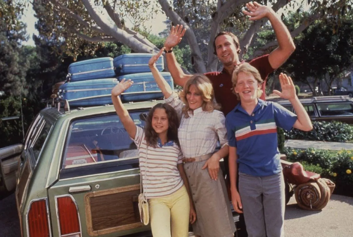 family waving by a packed car in vacation