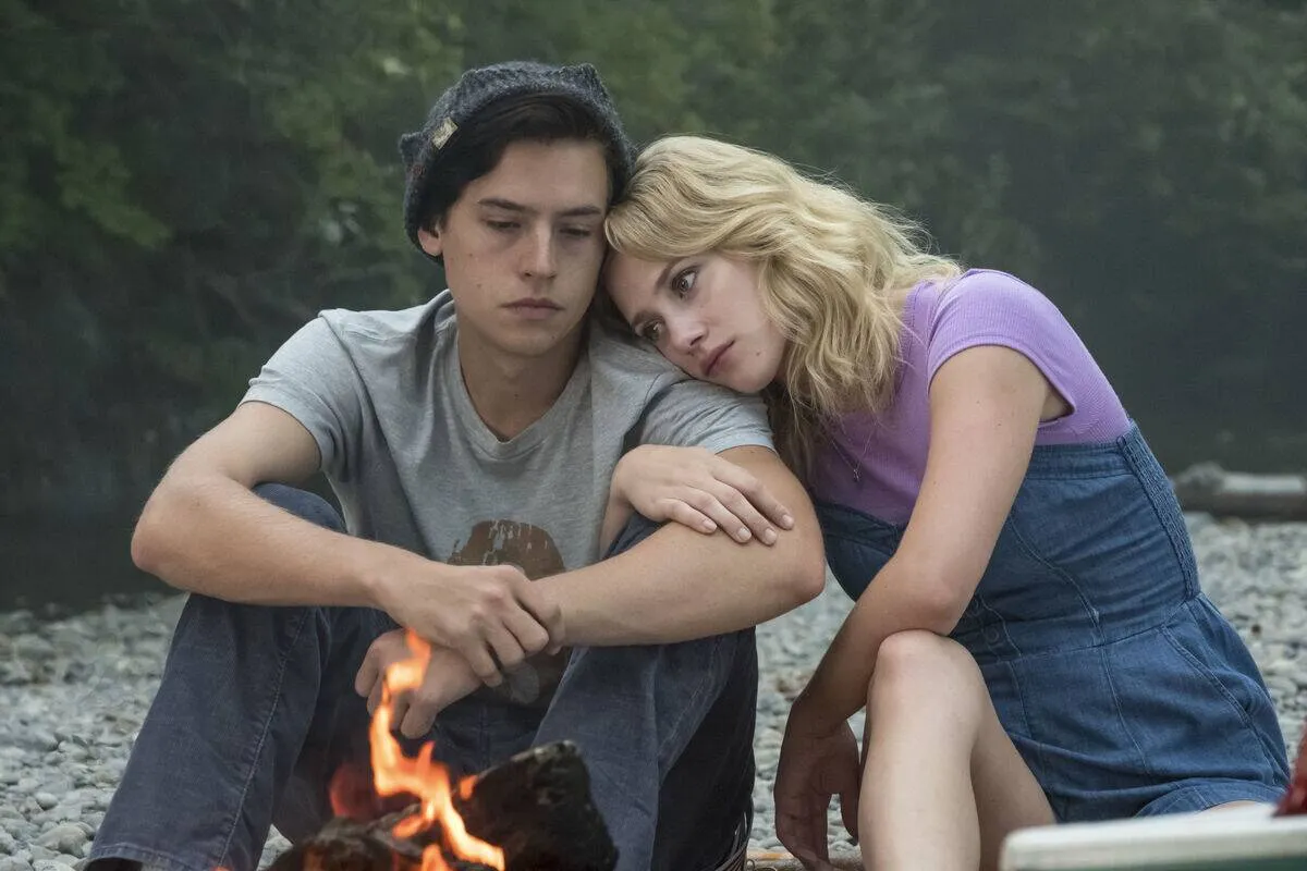 Cole Sprouse and Lili Reinhart embracing sadly as Jughead Jones and Betty Cooper in Riverdale
