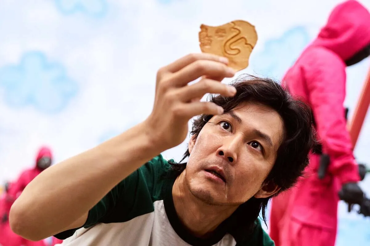 Lee Jung-jae looking at clay piece as Seong Gi-hun in Squid Game