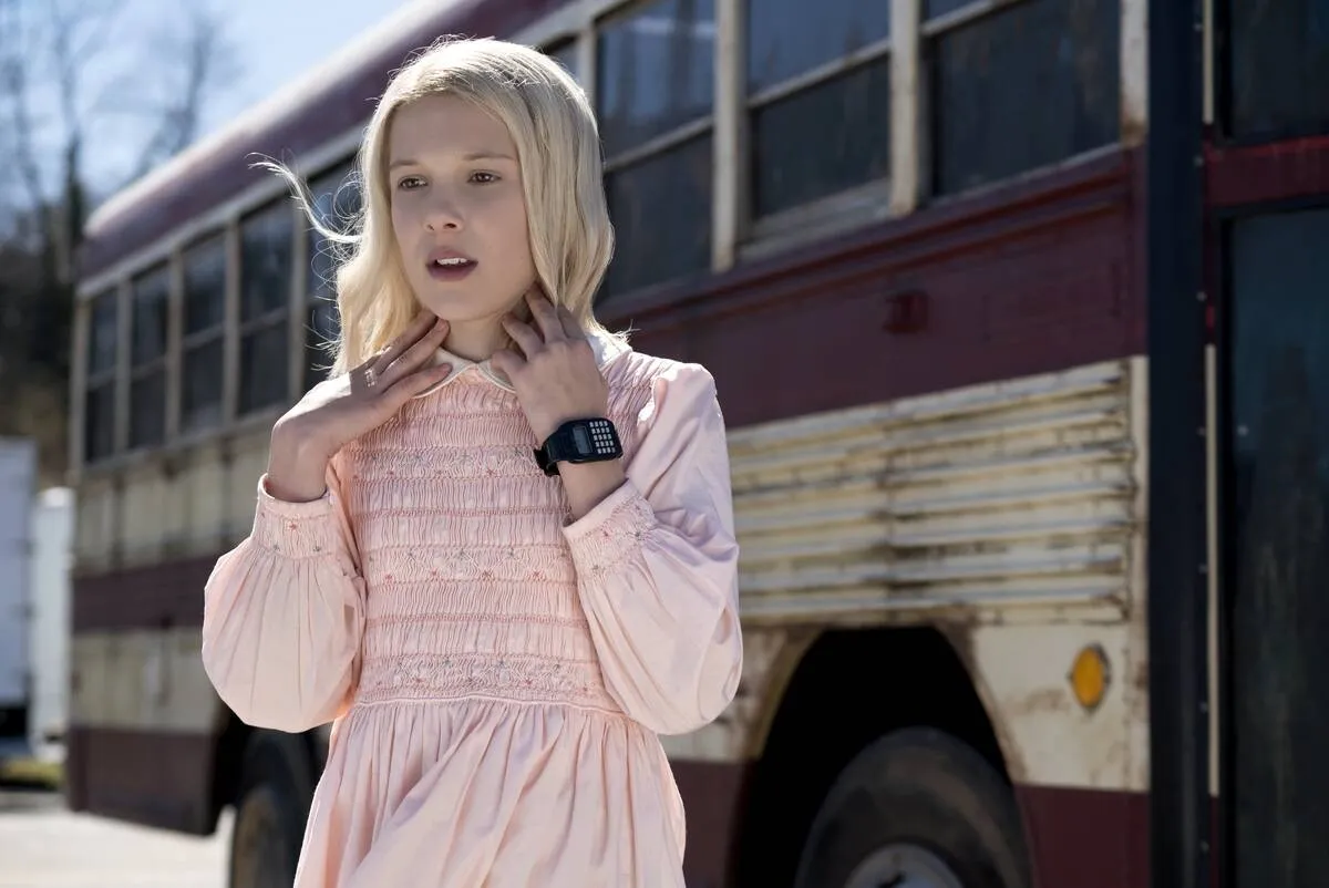 Millie Bobby Brown in front of bus as Jane 'Eleven' Hopper in Stranger Things