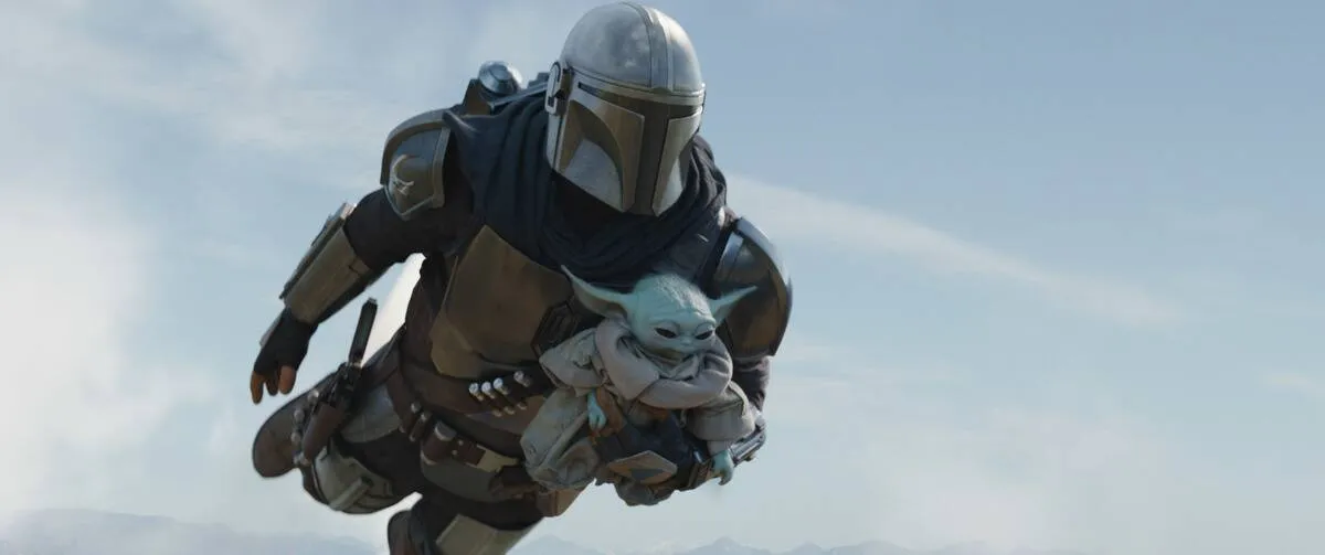 Pedro Pascal flying with Baby Yoda as Din Djarin in The Mandalorian
