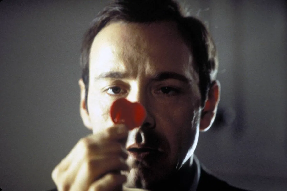 Kevin Spacey looking at heart-shaped lollipop as Lester Burnham in American Beauty