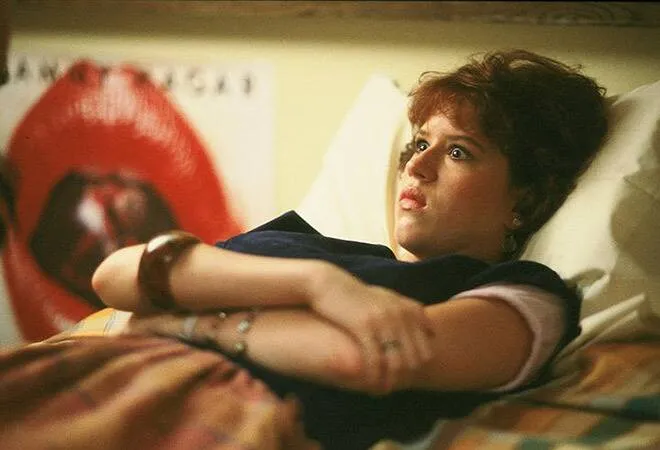 Molly Ringwald laying in bed as Samantha in Sixteen Candles